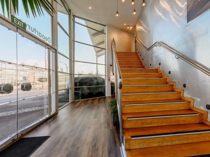 Interior staircase with timber treads, metal handrail and floor-to-ceiling windows