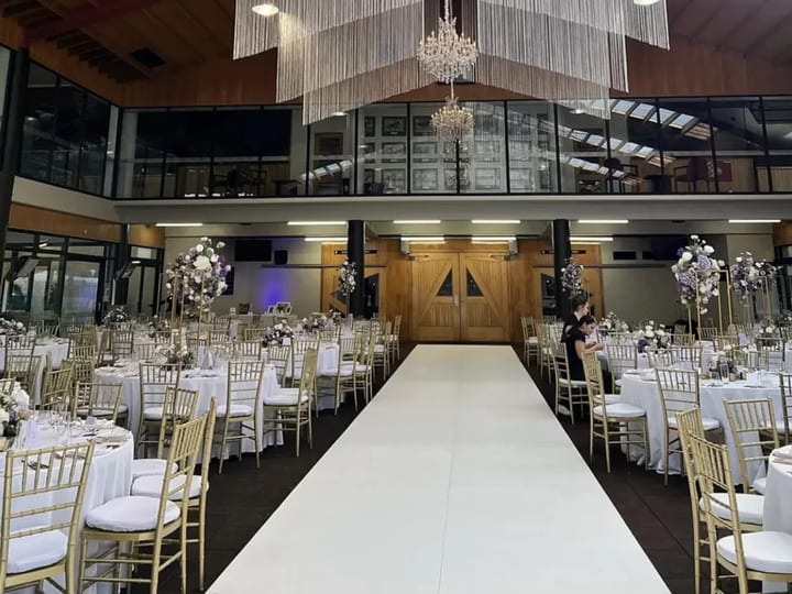 Pavilion interior with hanging chandelier installations and aisle for wedding ceremony