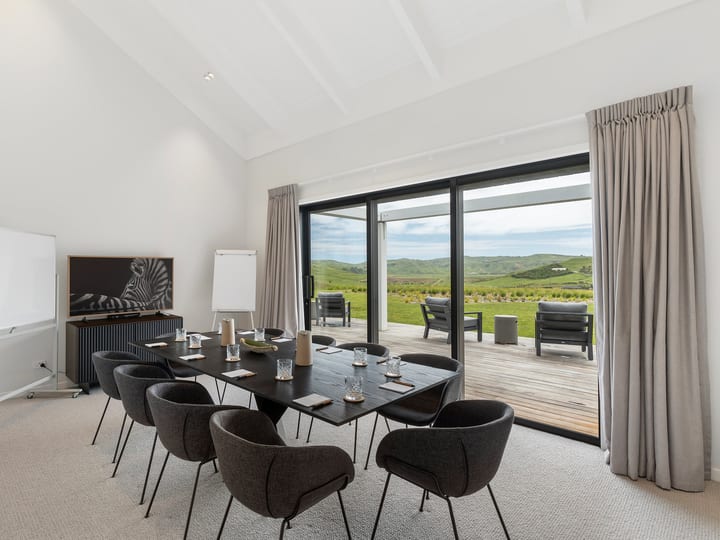 Meeting room with dark table, upholstered chairs and open rural views