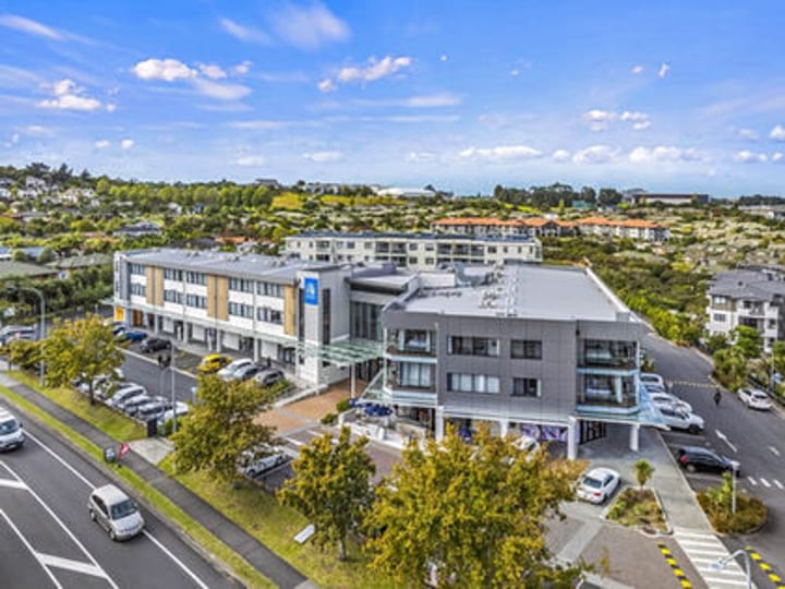 Aerial view of multi-storey hotel with surrounding rooftops and car park