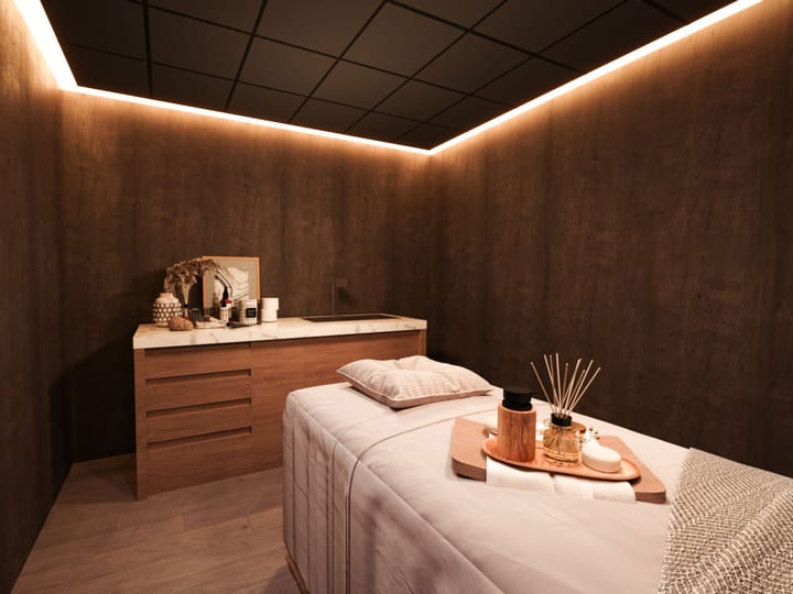 Spa treatment room with massage table and warm ambient lighting