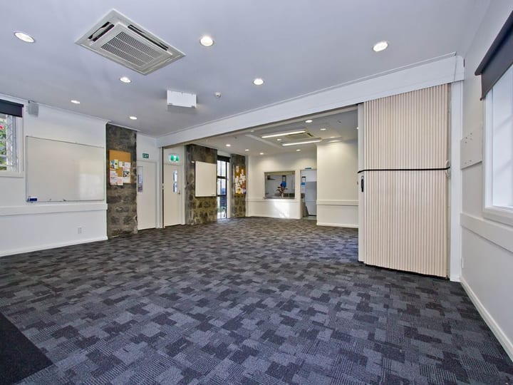 Open carpeted function room with folding partition door open to adjoining space