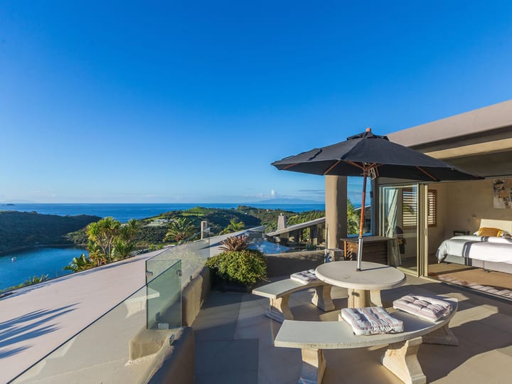 Villa terrace with outdoor seating, parasol and sea view adjacent to bedroom
