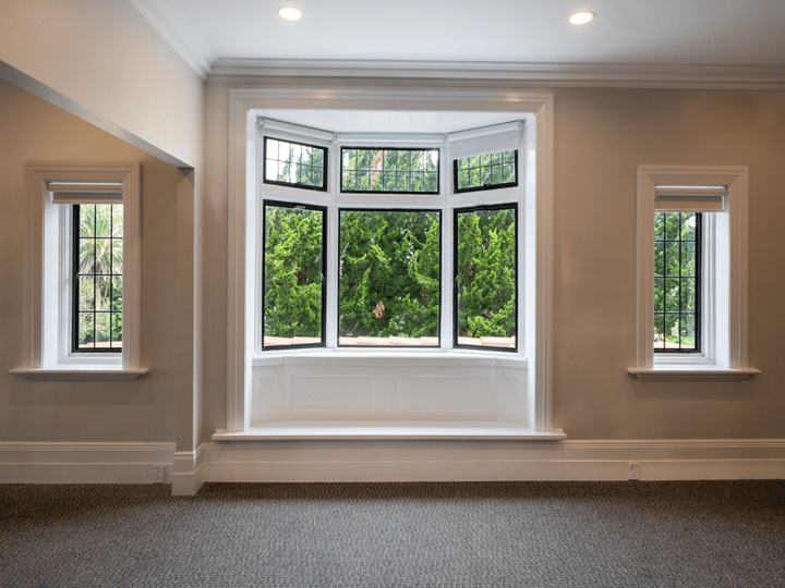 Bay window with lattice panes and garden view, carpeted room