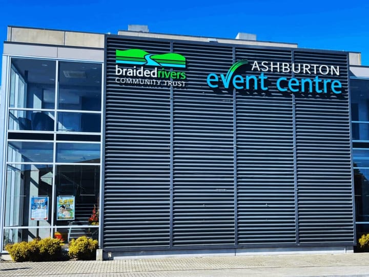 Modern event centre exterior in daylight with dark louvred facade and glazed sections