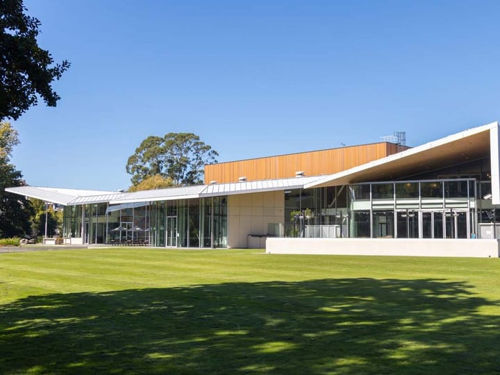 Contemporary building with timber and glass facade set beside a lawn
