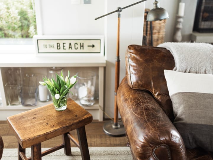 Sitting room corner with leather chair, side table and coastal decor