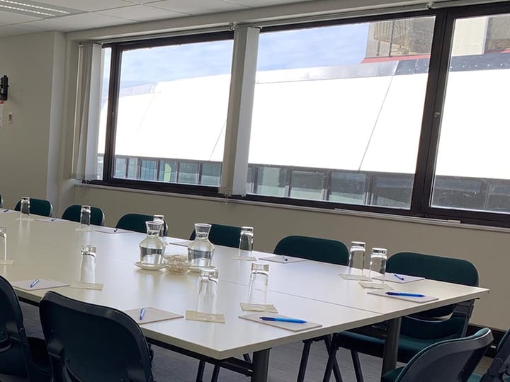 Conference room with large u-shaped table layout and harbour views