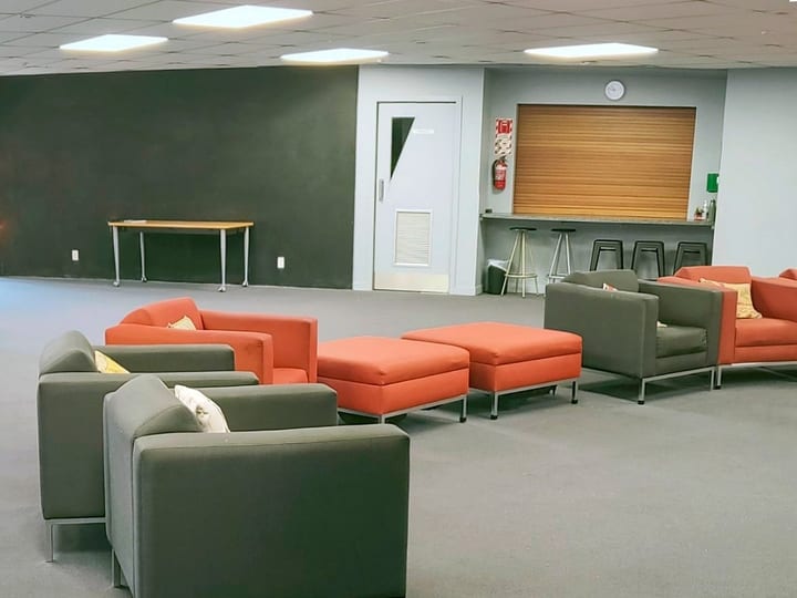 Lounge area with grey and orange modular seating and bar stools