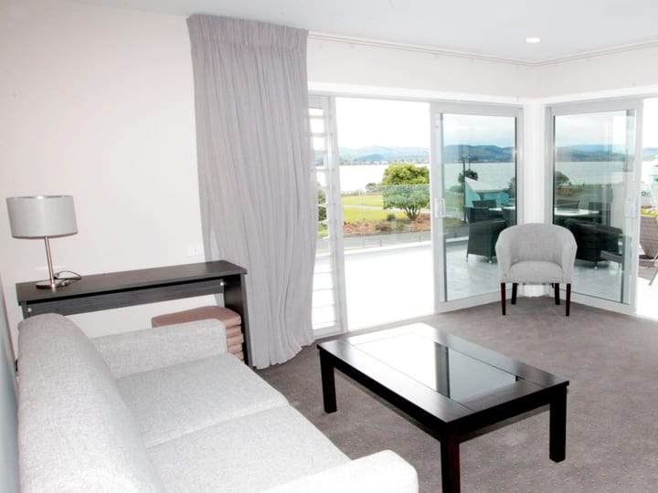 Lounge suite with sofas and glass doors opening to sea views
