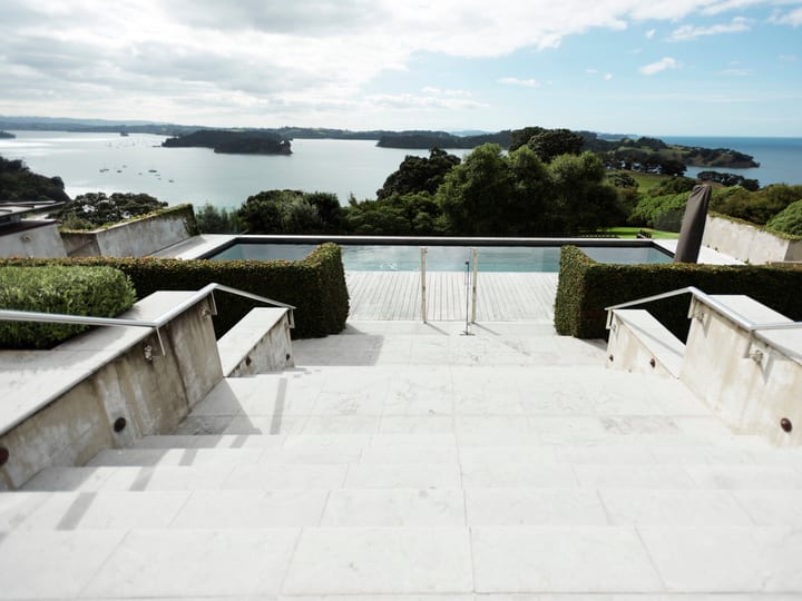 Terrace steps leading down to infinity pool with bay and island views
