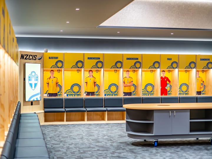 Sports changing room with lockers, player photos and a central briefing table