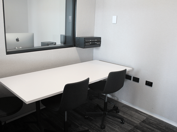 Compact studio observation room with bench, chairs and glass window