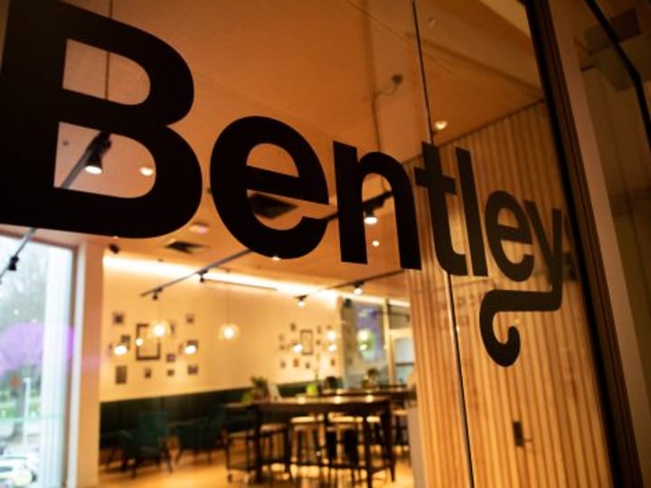Venue interior with dining area viewed through glass door with branding