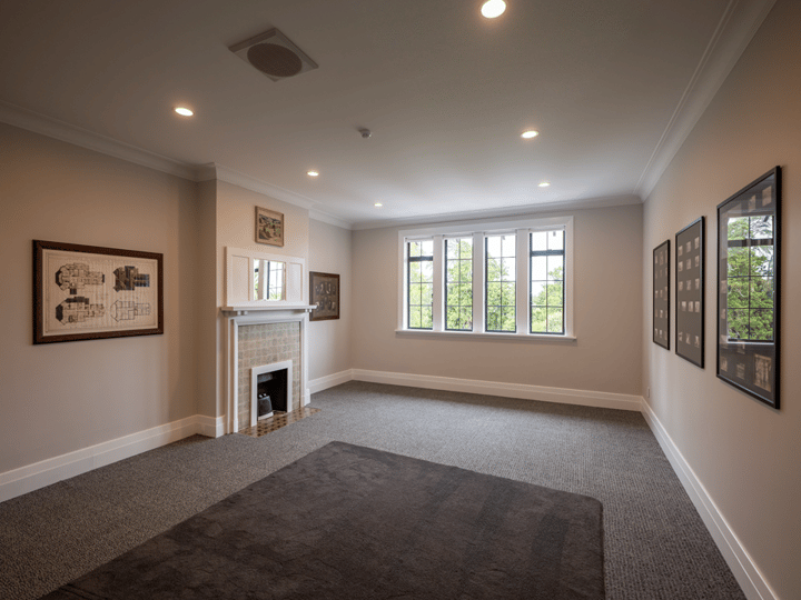 Carpeted meeting room with fireplace, framed artworks and large windows