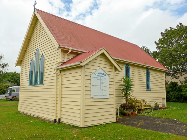 Cream weatherboard church with red roof, arched windows and signage reading St Martins Wainuireu Community Church