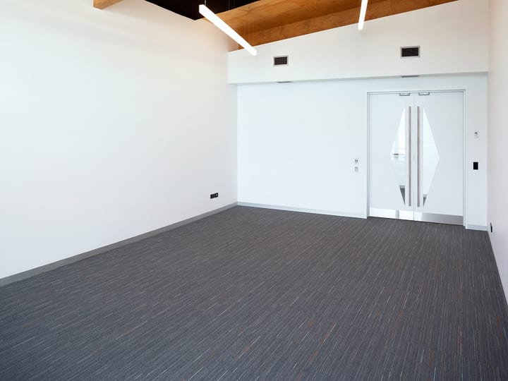 Neutral event or meeting room with sliding glass doors and minimalist white walls
