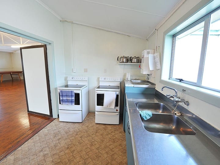 Hall kitchen with stainless steel sinks, stoves and cabinetry