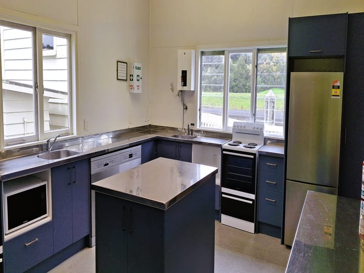 Hall kitchen with blue cabinetry, stainless benches and central island