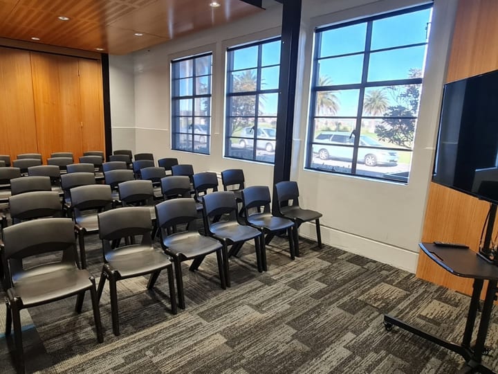Small empty room with tall windows and timber folding door