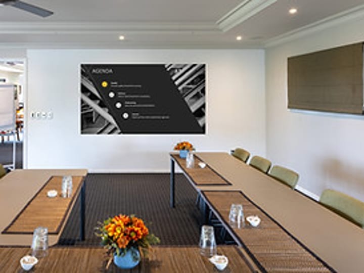 Meeting room with U-shaped table arrangement and presentation screen