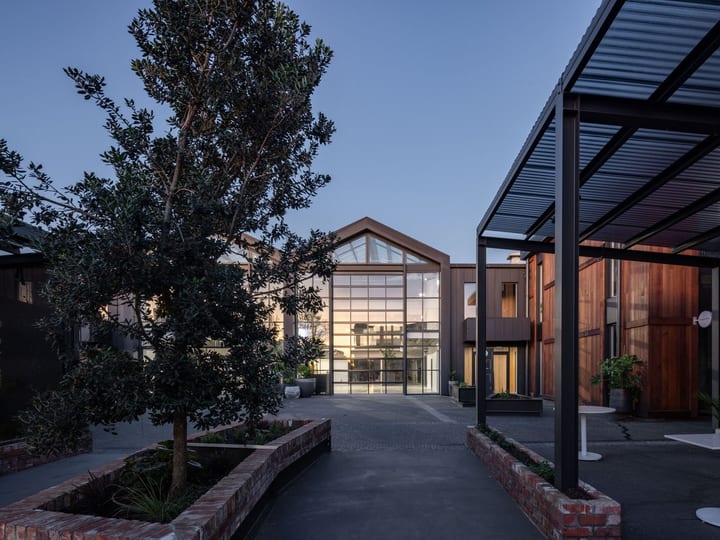 Venue courtyard at dusk with glowing gabled glazed atrium and covered outdoor area
