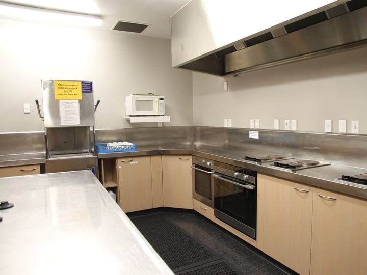 Commercial kitchen with stainless steel benches and appliances