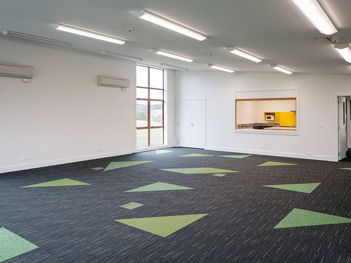 Open function room with patterned carpet tiles and servery hatch