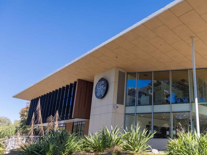 Close-up of building entrance with overhanging canopy and glazed facade