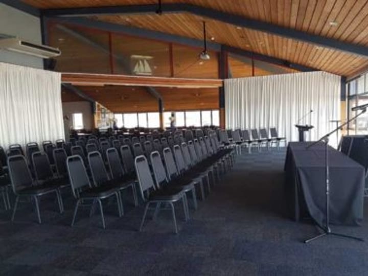 Function room set theatre-style with rows of chairs and timber ceiling