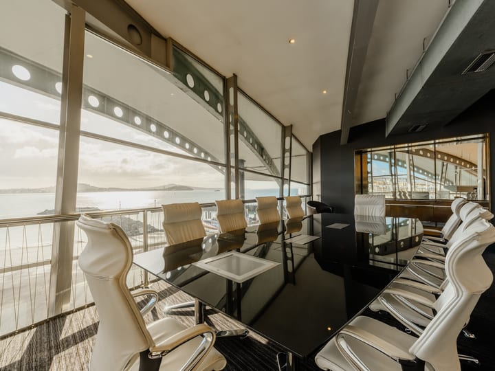 Upper-level meeting room with floor-to-ceiling harbour views and executive chairs