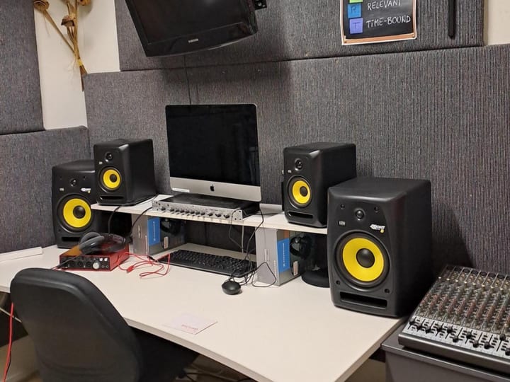Recording studio desk with monitor speakers, iMac, and audio interface