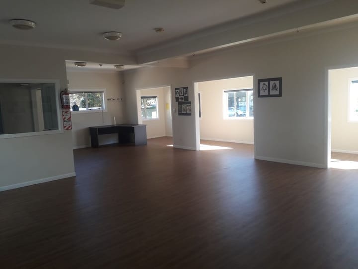 Open plan hall interior with timber floor and multiple room openings