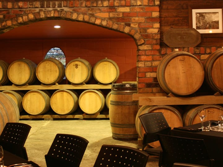 Wine barrel cellar dining room with exposed brick and arched wall