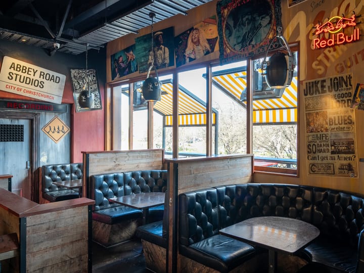 Bar seating area with music posters, vintage signs and leather banquette booths