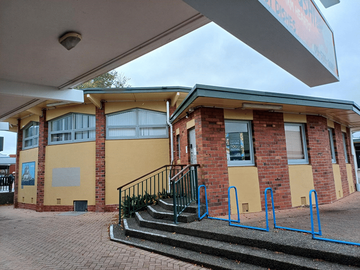 Brick building exterior with steps, handrails and side access door