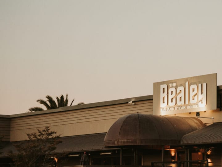 The Bealey signage lit up on a low-rise commercial building at dusk