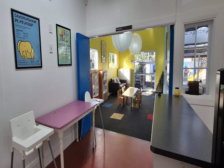 Reception and playgroup room with children's furniture and yellow walls visible