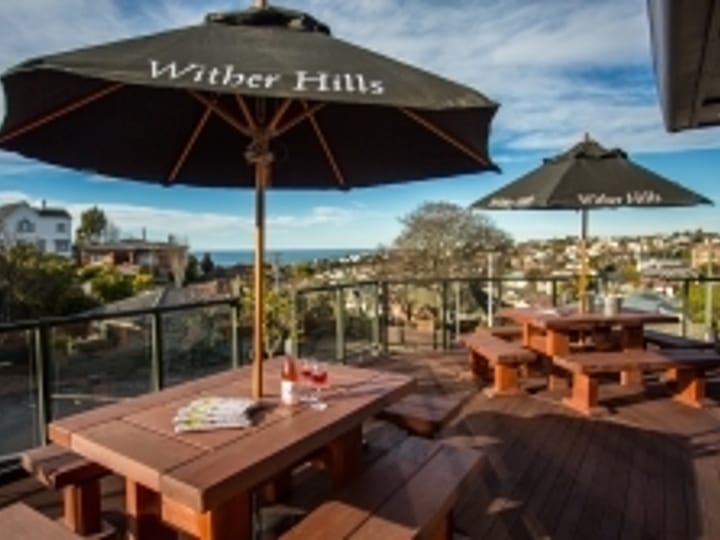 Rooftop deck with outdoor tables, umbrellas, and harbour views