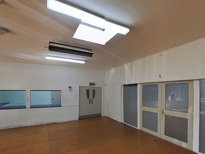 Meeting room with tables, chairs, carpet and windows with curtains