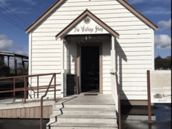 Small white weatherboard building with gable roof and entry steps