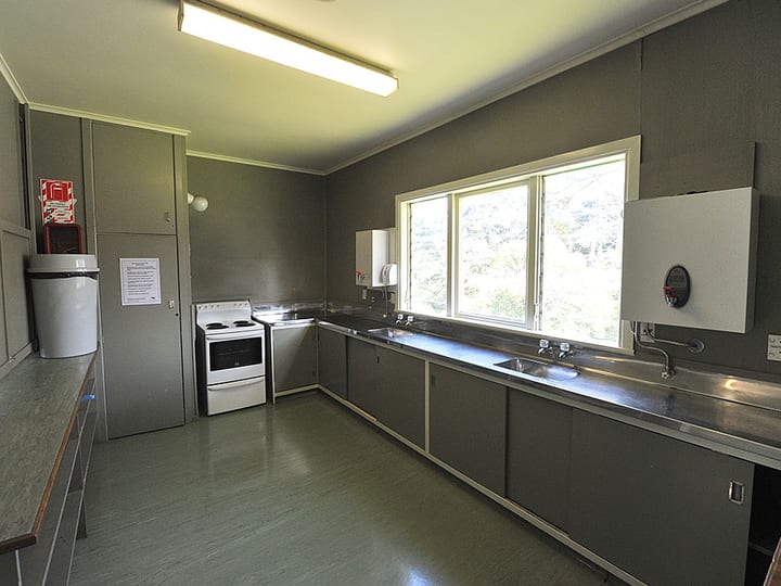 Plain kitchen with grey cabinetry, stove, and stainless bench