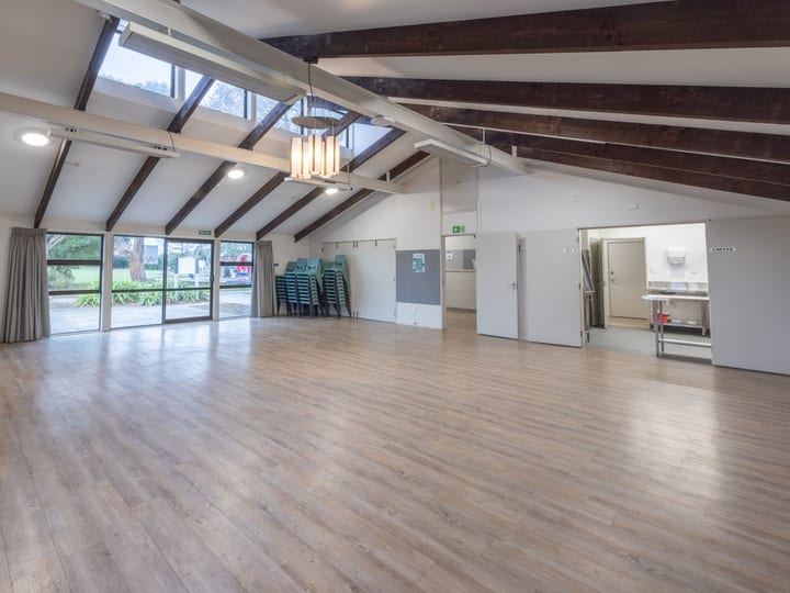 Community hall interior with exposed timber roof beams and timber floor