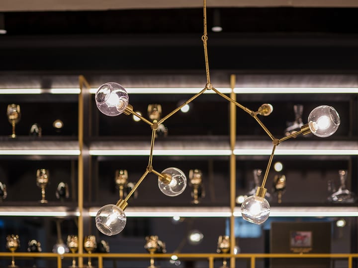 Pendant lights and gold lamp hanging from dark timber-beamed ceiling