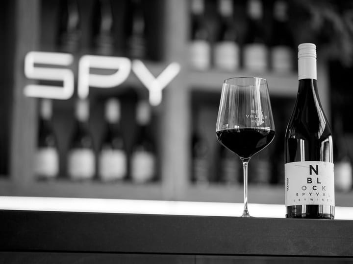 Wine glass and bottle on cellar door counter in black and white