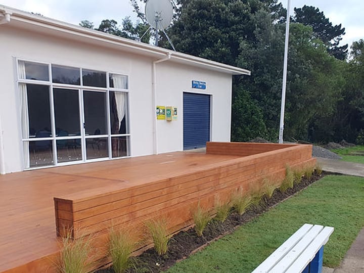 Club building with timber deck, garden bed, and bench seating