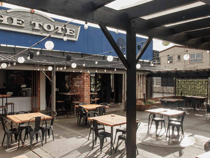 High-top bar tables with stools, screens, and booth seating along the walls