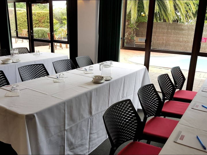 Function room with classroom tables and garden-view windows