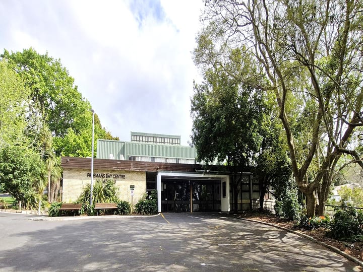 Brick and weatherboard community centre building surrounded by trees