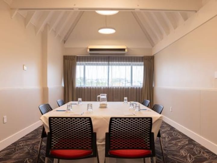Small boardroom with central table and chairs under pitched ceiling